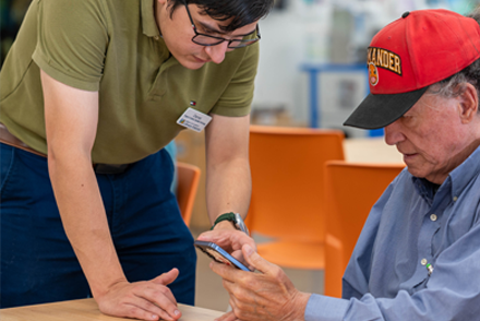person helping another with their phone